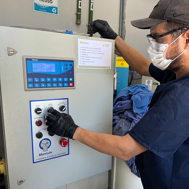 Profissional da Green Washer operando painel de controle de equipamento de lavanderia industrial